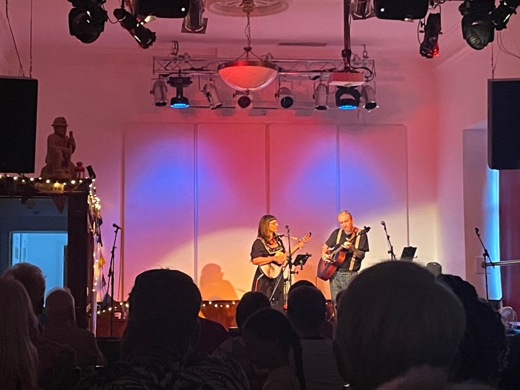 alt="Max and Veronica performing at the Laxey Working Men’s Institute on the Isle of Man, July 2025."